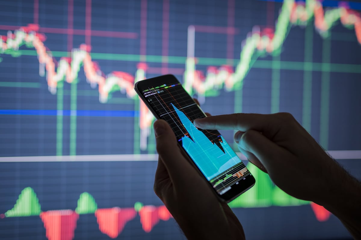Trader checking live stock market data on a phone